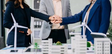 Çok ırklı iş adamlarından oluşan bir grup, konut projesinden yola çıkarak bina modeline bakıyor ve el sıkışıyor. Yeşil iş şirketi ve Güneş Enerjisi Çevre Kenti Kavramı.