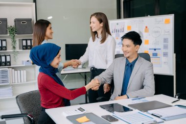 İş ortaklığı tokalaşması. Çok ırklı takım arkadaşları el sıkışma sürecinde. Büyük toplantıdan sonra başarılı bir anlaşma..