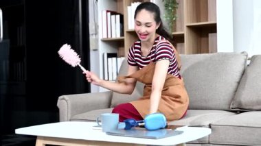 Genç Asyalı kadın evini temizliyor. Milenyum ev hanımı ev işlerini yapıyor, ev temizliği yapıyor.
