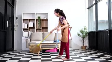 Genç Asyalı kadın evini temizliyor. Milenyum ev hanımı ev işlerini yapıyor, ev temizliği yapıyor.