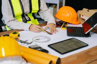 Mimarlığın orta bölümü modern ofisteki bir mimari projenin planında çalışıyor.. 