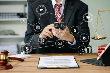 Adalet ve hukuk kavramı. Mahkeme salonunda çalışan ve akıllı telefon ve dijital tablet kullanan bir erkek yargıç. 