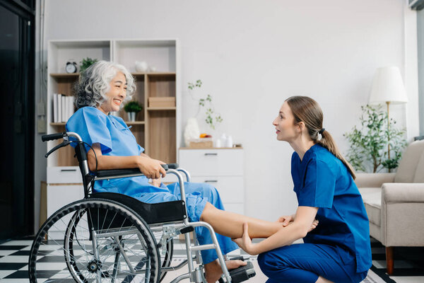 Physiotherapist helping elderly female patient on wheelchair stretching leg during exercise correct 