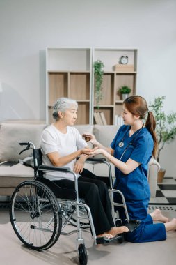 Doktor, yaşlı kadın hastaya evde ilaç veriyor. Tekerlekli sandalyede oturan yaşlı kadınla ilgilenen terapist. Tıbbi servis kavramı  