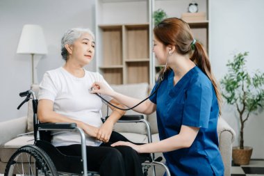 Doktor steteskop kullanan yaşlı bir hastanın kalp atışlarını inceliyor. Tekerlekli sandalyede oturan yaşlı bir kadınla ilgilenen terapist. Tıbbi servis kavramı