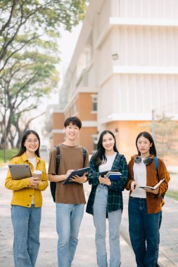 Üniversite öğrencileri sabahları kampüs parkında dizüstü bilgisayarla çalışıyorlar. 
