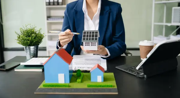 Stock image Real estate broker agent presenting house model in office