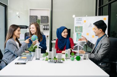 İş adamlarının şirket ofisinde rüzgar enerjisi hakkında görüşleri var. İş ekibi yel değirmenleri ve alternatif yeşil enerji hakkında konuşuyor. Ağ sıfır ve karbon nötr konsept.