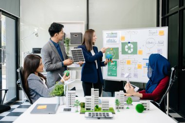 İş adamlarının şirket ofisinde rüzgar enerjisi hakkında görüşleri var. İş ekibi yel değirmenleri ve alternatif yeşil enerji hakkında tartışıyor