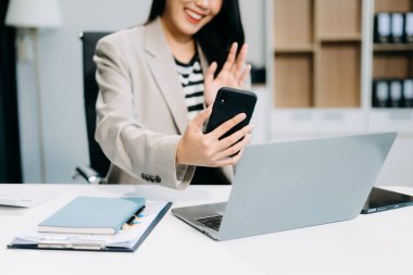 Akıllı telefon ve laptop ofisi kullanan bir iş kadını. 