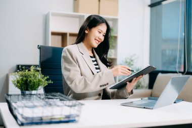 İş kadını, ofis masasında dizüstü bilgisayar kullanarak matematik finansmanı yapıyor.