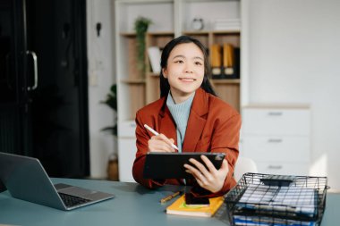  Güzel Asyalı kadın ofisinde oturuyor.