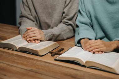 Bir grup Hıristiyan birlikte oturup ahşap bir masanın etrafında otururlar ve sınıfta bulanık incille dua ederler. Allah 'ın lütuf ve ihsanını dileyin..