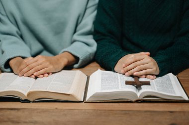 Bir grup Hıristiyan birlikte oturup ahşap bir masanın etrafında otururlar ve sınıfta bulanık incille dua ederler. Allah 'ın lütuf ve ihsanını dileyin..