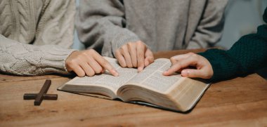 Hıristiyanlar, Allah 'ın lütfunu kazanmak için el ele tutuşurlar. Tahta masada.