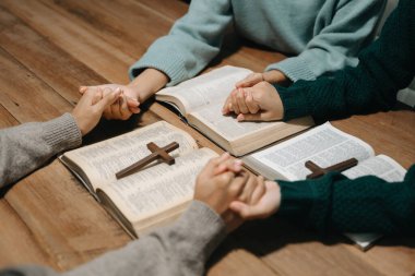 Bir grup Hıristiyan birlikte oturup ahşap bir masanın etrafında otururlar ve sınıfta bulanık incille dua ederler. Allah 'ın lütuf ve ihsanını dileyin..