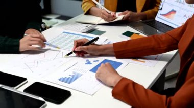 İş Adamları Strateji Planlama Analiz Ofisi Konsepti. Çalışma arkadaşları not yazıyor ve dizüstü bilgisayar, tablet ve akıllı telefonlar kullanıyorlar.