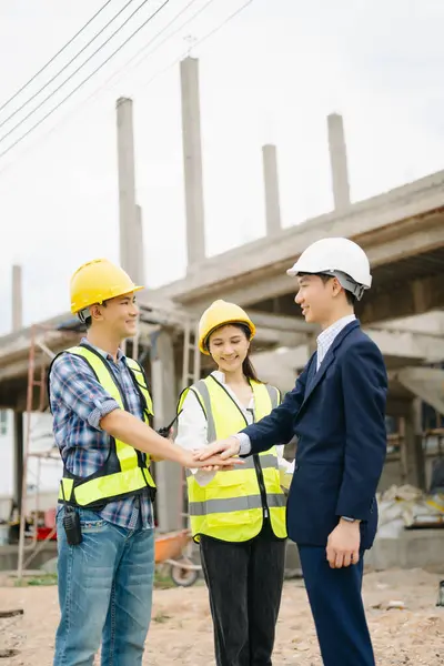 stock image Architect Asian team working with colleagues in the construction site. Architecture engineering on big project. Building in construction process interior.