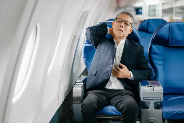 stock image Photo of a frustrated senior man sitting on an airplane with headache 