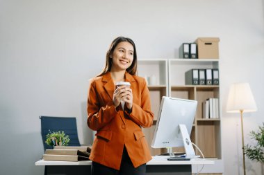 Kendine güvenen iş kadını yaratıcı ofiste kahve içiyor.
