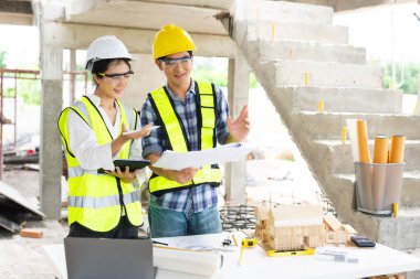 Mühendis ekibi toplantısı, inşaat alanının mimari proje planı ve profesyonel endüstri ekibiyle birlikte çalışıyoruz.