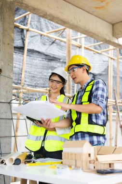 Mühendis ekibi toplantısı, inşaat alanının mimari proje planı ve profesyonel endüstri ekibiyle birlikte çalışıyoruz.