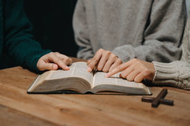 Hıristiyanlar, Allah 'ın lütfunu kazanmak için el ele tutuşurlar. Tahta masada.
