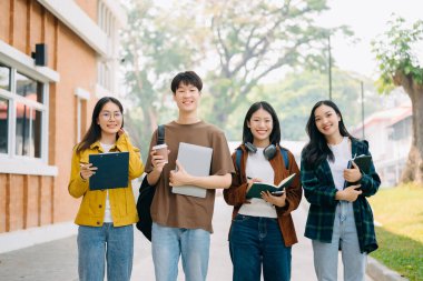 Mutlu Asyalı üniversite öğrencileri kampüs parkında sabahları