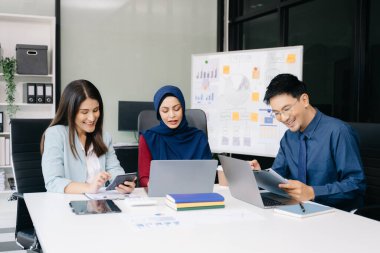 Çok ırklı genç yaratıcı insanlardan oluşan bir grup iş görüşmelerini tartışıyor fikir üreten tasarım projelerini ofisinde tartışıyor.