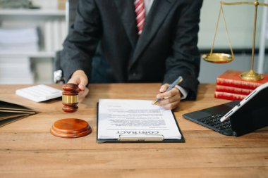 Adalet ve hukuk kavramı. Bir mahkeme salonunda erkek yargıç. Tokmak, ofiste akıllı telefon ve dizüstü bilgisayarla çalışıyor.