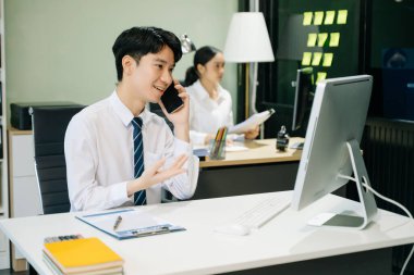 Modern ofiste çalışan Asyalı takım elbiseli genç ofis çalışanları.