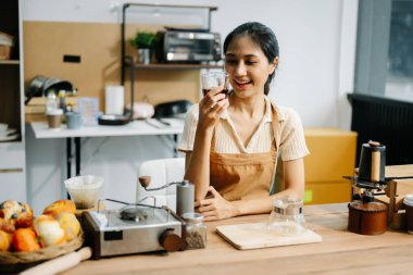 Profesyonel Asyalı barista kafede çalışırken kahve yapıyor ve tadıyor.