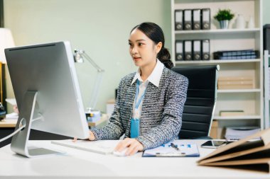 Modern ofiste takım elbiseli genç ve çekici Asyalı bir ofis çalışanı.