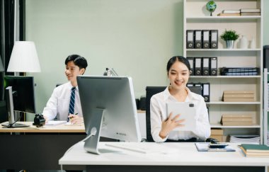 Modern ofiste çalışan Asyalı takım elbiseli genç ofis çalışanları.