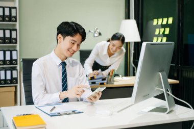 Modern ofiste çalışan Asyalı takım elbiseli genç ofis çalışanları.