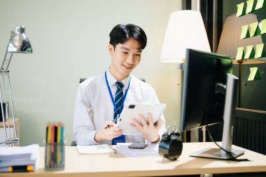 Genç Asyalı işadamı modern ofiste çalışıyor.