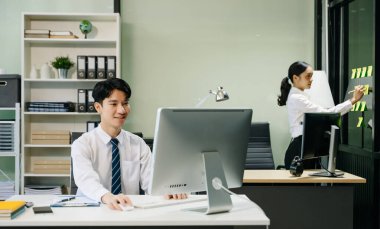 Modern ofiste çalışan Asyalı takım elbiseli genç ofis çalışanları.