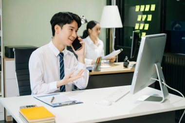 Modern ofiste çalışan Asyalı takım elbiseli genç ofis çalışanları.