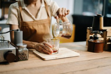 Kafede çalışırken kahve yapan Asyalı profesyonel bir barista.