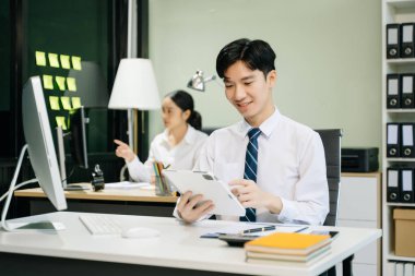 Modern ofiste çalışan Asyalı takım elbiseli genç ofis çalışanları.
