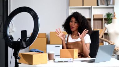 Moda blogcusu konsepti, video yayınında elbise satan genç bir kadın yüzük lambası ve akıllı telefon kullanıyor. Küçük işletme kavramı başlat.