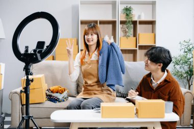 Küçük işletmeler kurmak KOBİ sahipleri, çevrimiçi siparişleri kontrol etmek, ürünleri satmak, kutularla çalışmak ve akıllı telefon ve yüzük lambası kullanmak, merkez büroda serbest çalışmak 