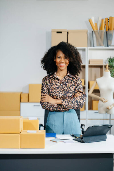 Владелец афроамериканского предпринимателя женщина готовит упаковку продуктов коробки для покупок онлайн заказов. Концепция запуска малого бизнеса.