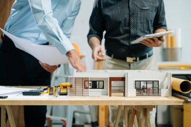 Bir iş toplantısının mimarları, modern bir yapı modelini planlamak ve tartışmak, mimari tasarımda takım çalışması ve yaratıcılığı sergilemek