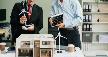 Bir iş toplantısının mimarları, modern bir yapı modelini planlamak ve tartışmak, mimari tasarımda takım çalışması ve yaratıcılığı sergilemek