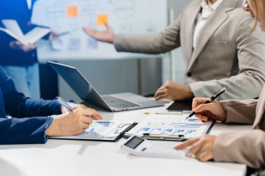 İş arkadaşları, dizüstü bilgisayarla ofiste yeni bir proje üzerinde tartışıyor ve çalışıyorlar. 