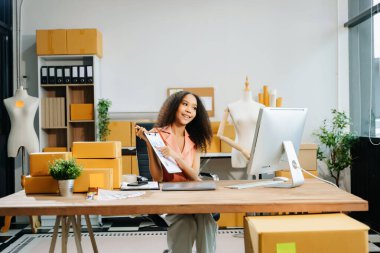 Küçük işletme girişimcisi ya da KOBİ 'li serbest çalışan iş kadını ev ofisinde bilgisayar, e-ticaret konsepti üzerinde çalışıyor