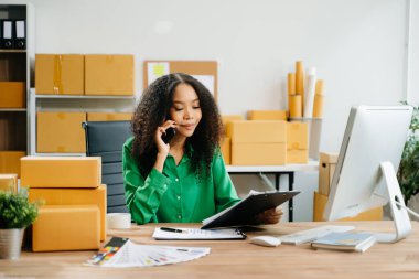 Başlangıçta küçük işletme KOBİ 'si, akıllı telefon ve bilgisayar kullanan girişimci kadın paket ürün kutularını hazırlamak için çevrimiçi satın alma siparişi alır ve kontrol eder