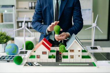 Ofis toplantı odasında ekolojik gayrimenkul sunan bir işadamı