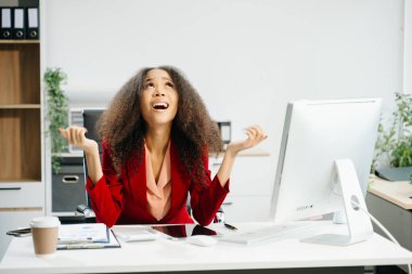 Asyalı iş kadını, modern ofisteki bir bilgisayarda çalıştığı için stresli, sıkılmış ve fazla düşünüyor.